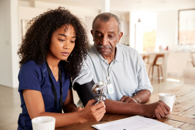 nurse checking senior man's blood pressure